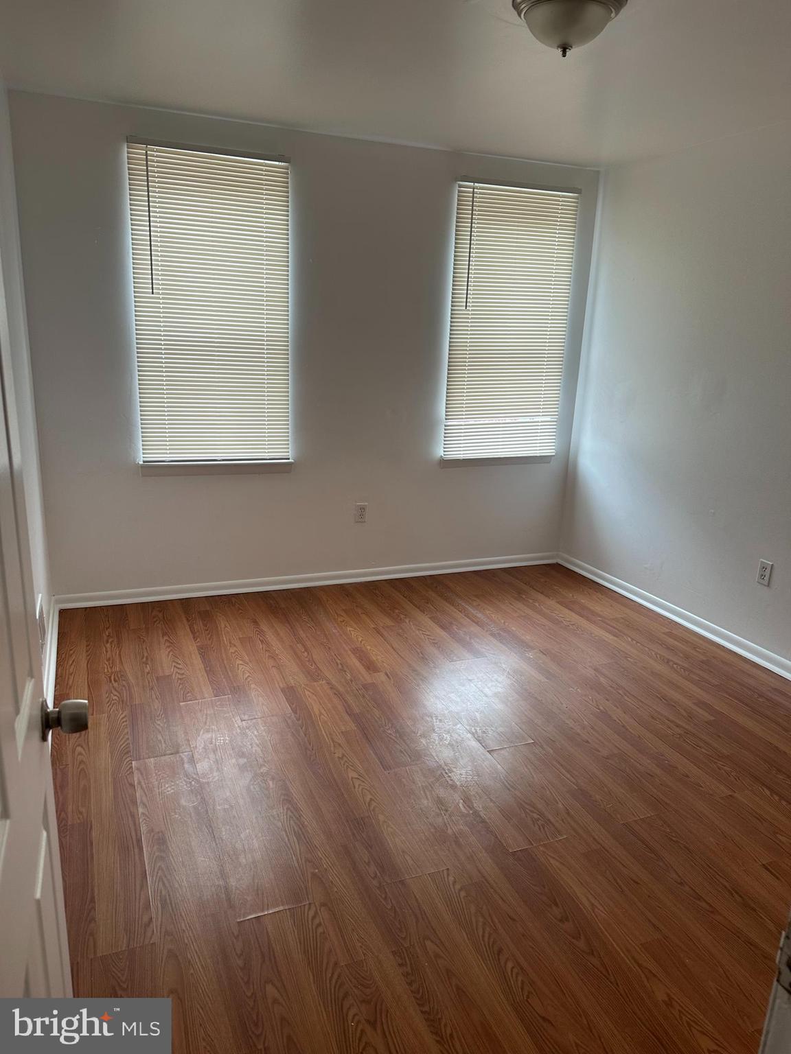 1707 North Dallas Street Baltimore, MD 21213 - Photo 6 of 12 an empty room with wooden floor and windows