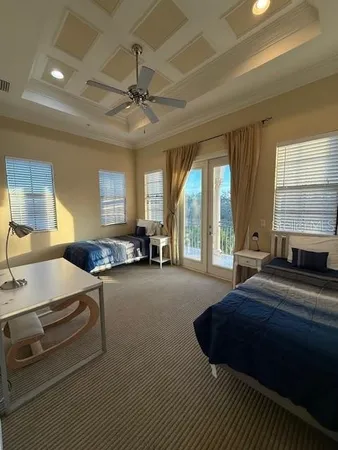 a spacious bedroom with a bed a chandelier and large window