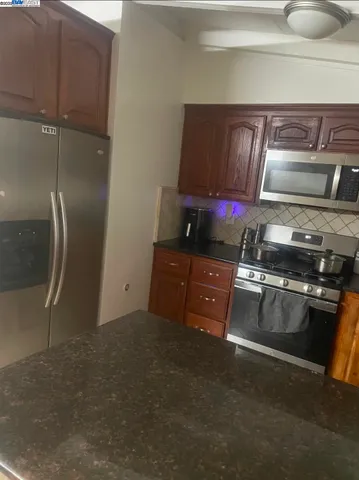 a kitchen with granite countertop a stove and a refrigerator