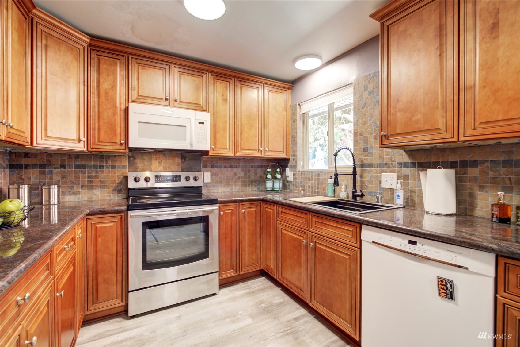 3612 Northeast 9th Street Renton, WA 98056 - Photo 11 of 23 a kitchen with granite countertop cabinets stainless steel appliances a sink and window