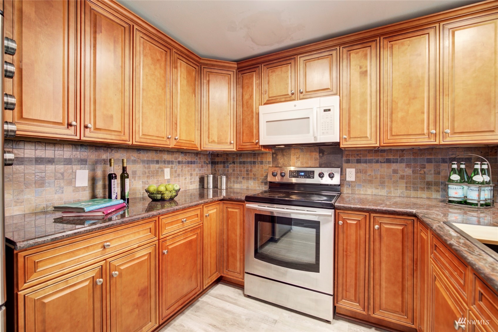 3612 Northeast 9th Street Renton, WA 98056 - Photo 12 of 23 a kitchen with granite countertop cabinets stainless steel appliances a sink and a window