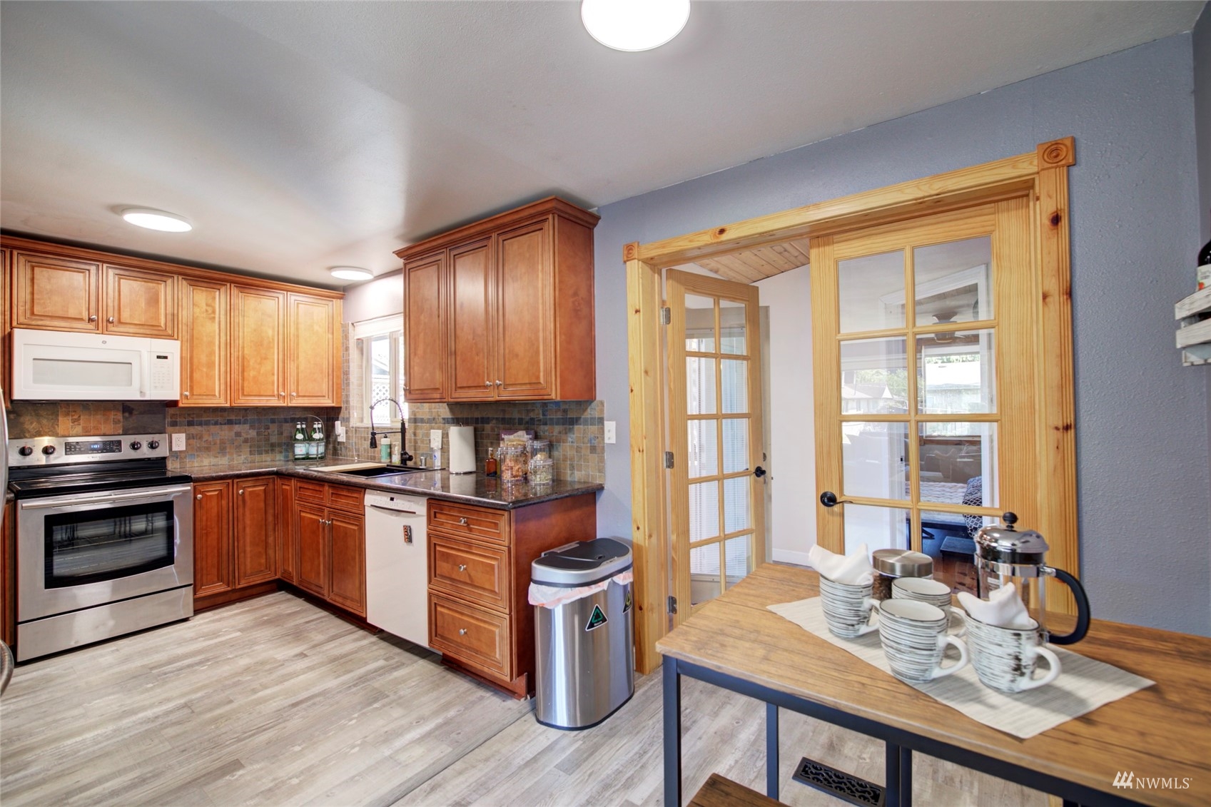 3612 Northeast 9th Street Renton, WA 98056 - Photo 10 of 23 a kitchen with stainless steel appliances granite countertop wooden cabinets a stove a sink and dishwasher with wooden floor