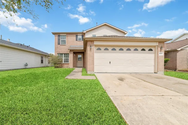 a front view of a house with a yard and garage