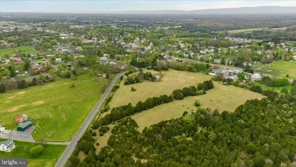 an aerial view of residential houses with outdoor space and trees