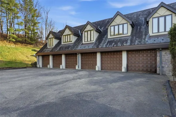 a front view of a house with yard and parking