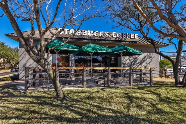 a front view of a building with trees