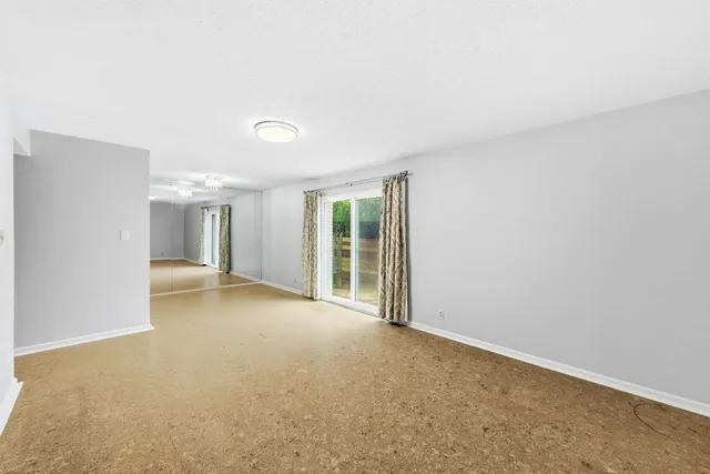 a view of a big room with windows and chandelier fan