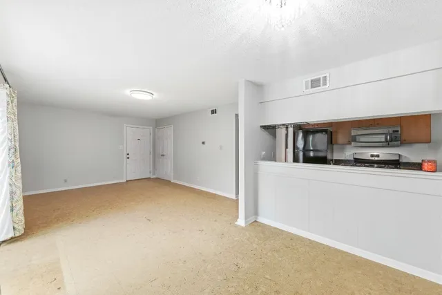 a kitchen with stainless steel appliances granite countertop a refrigerator and a stove top oven