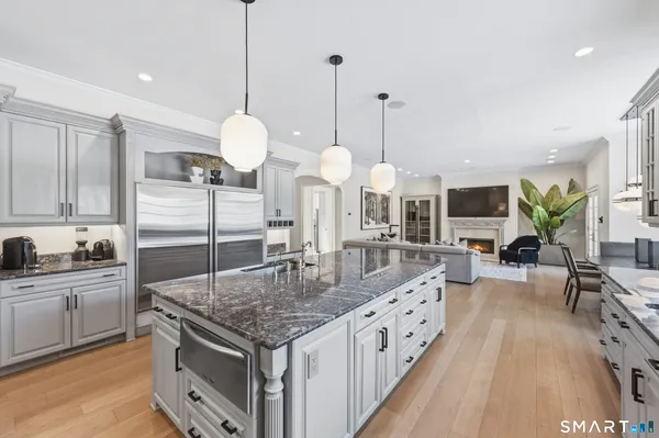 a kitchen with stainless steel appliances kitchen island granite countertop a stove a sink and a wooden floors