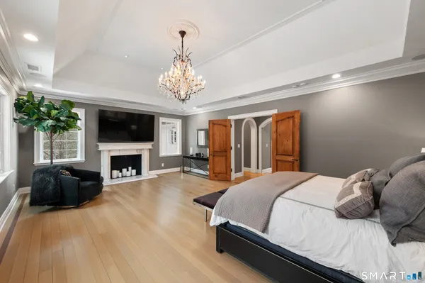 a spacious bedroom with a bed and a chandelier