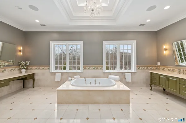 a spacious bathroom with a tub sink and mirror