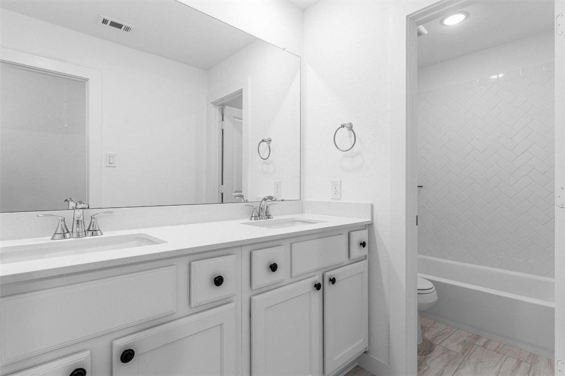 17351 Merigold Hts Drive Conroe, TX 77302 - Photo 30 of 49 a bathroom with a granite countertop sink a toilet and a mirror