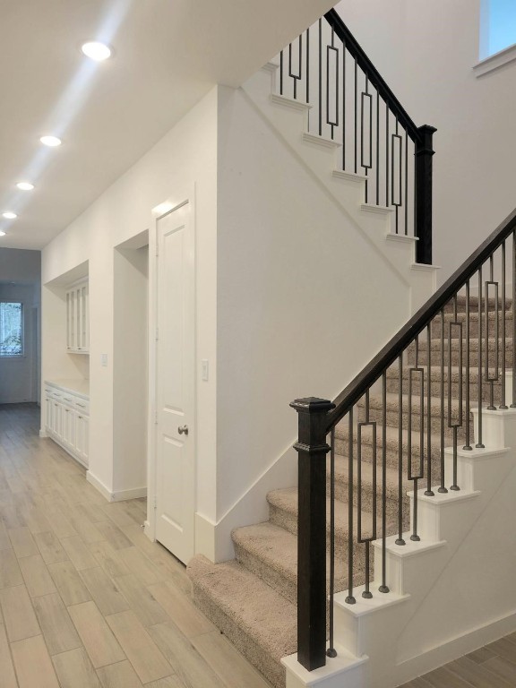 17351 Merigold Hts Drive Conroe, TX 77302 - Photo 6 of 49 a view of staircase with lots of frames on wall and wooden floor