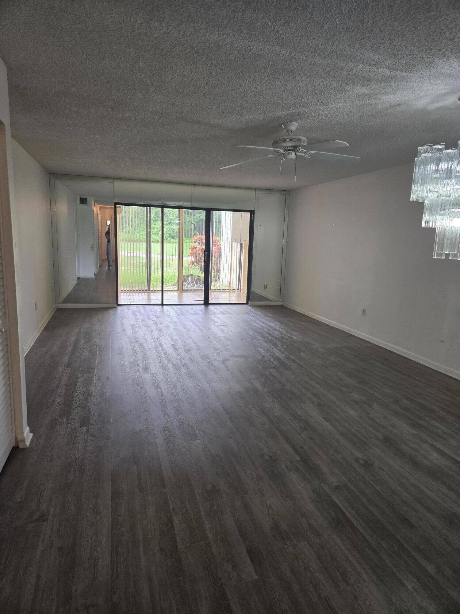 21213 Lago Circle, Unit G Boca Raton, FL 33433 - Photo 4 of 8 an empty room with wooden floor and windows