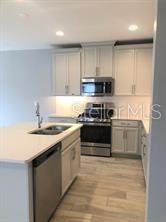 250 Evertree Loop Sanford, FL 32771 - Photo 4 of 19 a kitchen with stainless steel appliances a stove a sink and a microwave