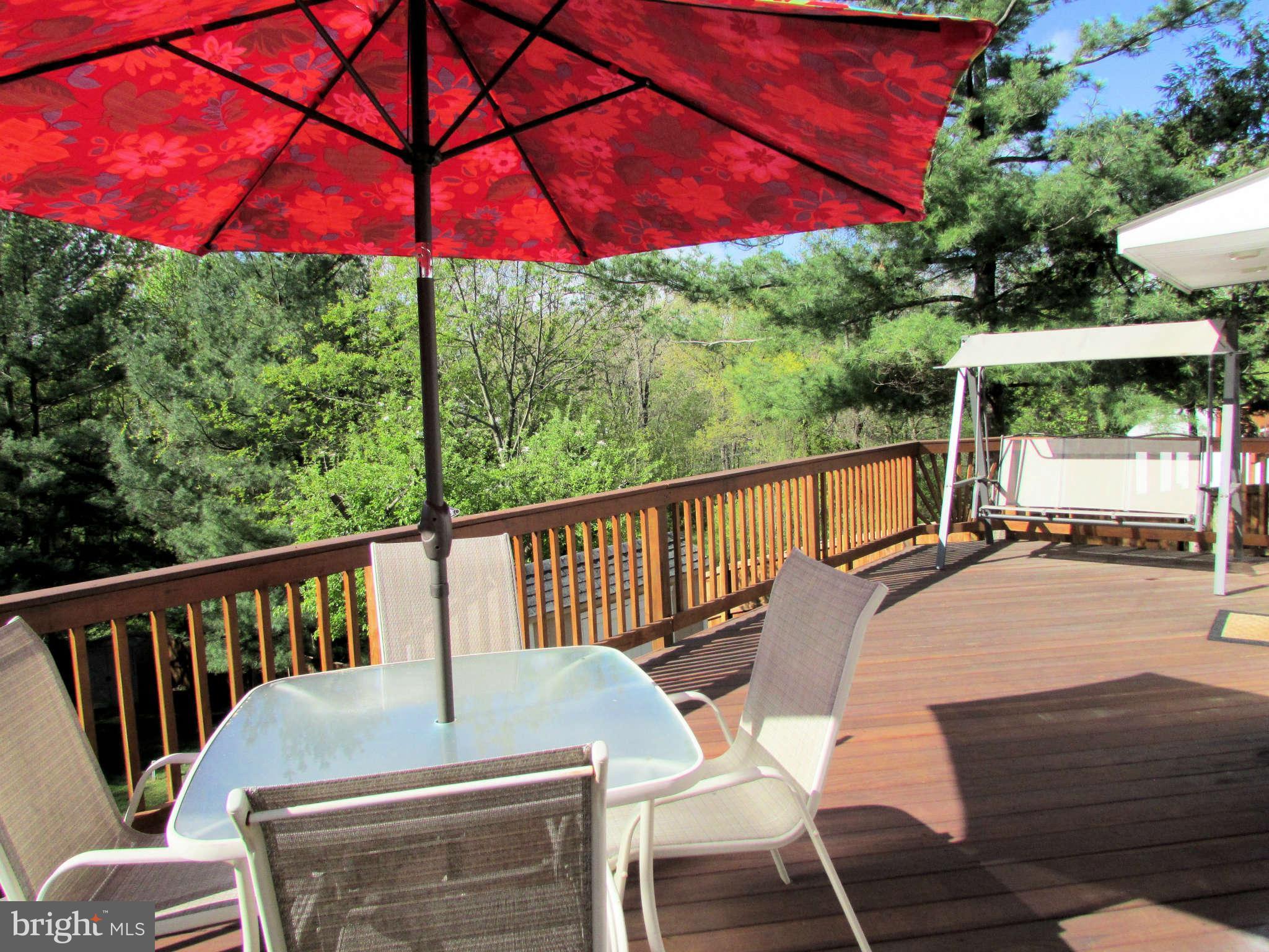 6915 Pinecrest Road Baltimore, MD 21228 - Photo 27 of 30 a view of a patio with table and chairs under an umbrella with a small yard