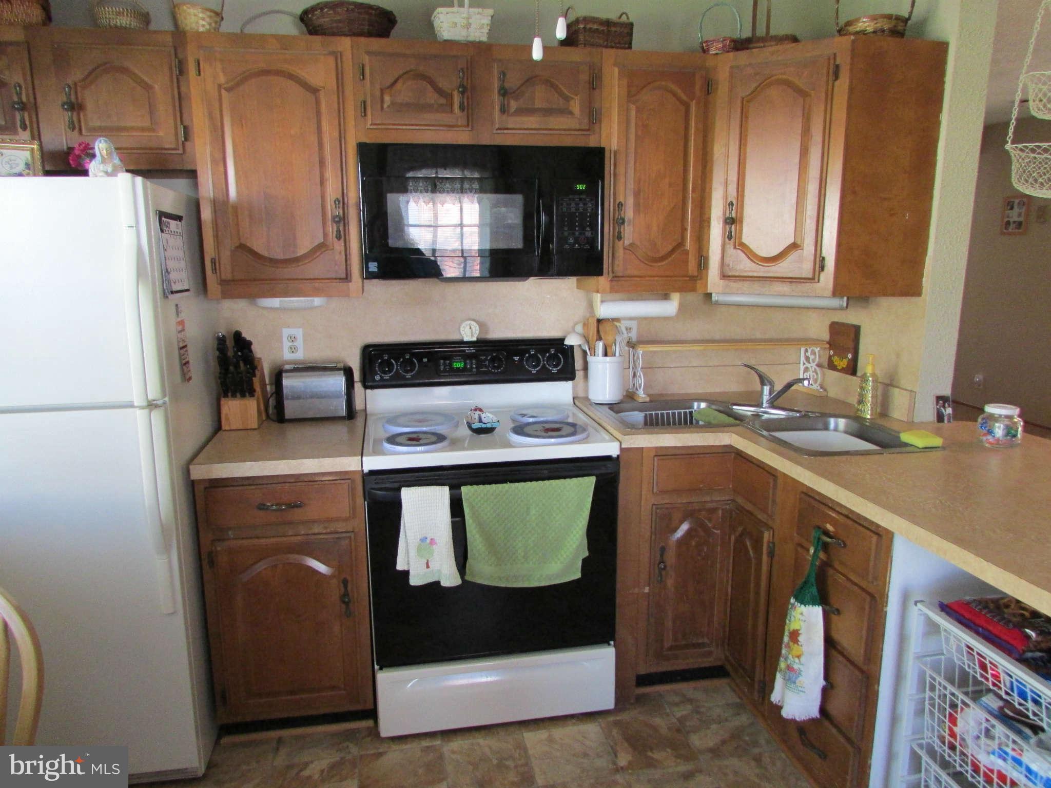 6915 Pinecrest Road Baltimore, MD 21228 - Photo 30 of 30 a kitchen with stainless steel appliances granite countertop a sink a stove a microwave a refrigerator and cabinets
