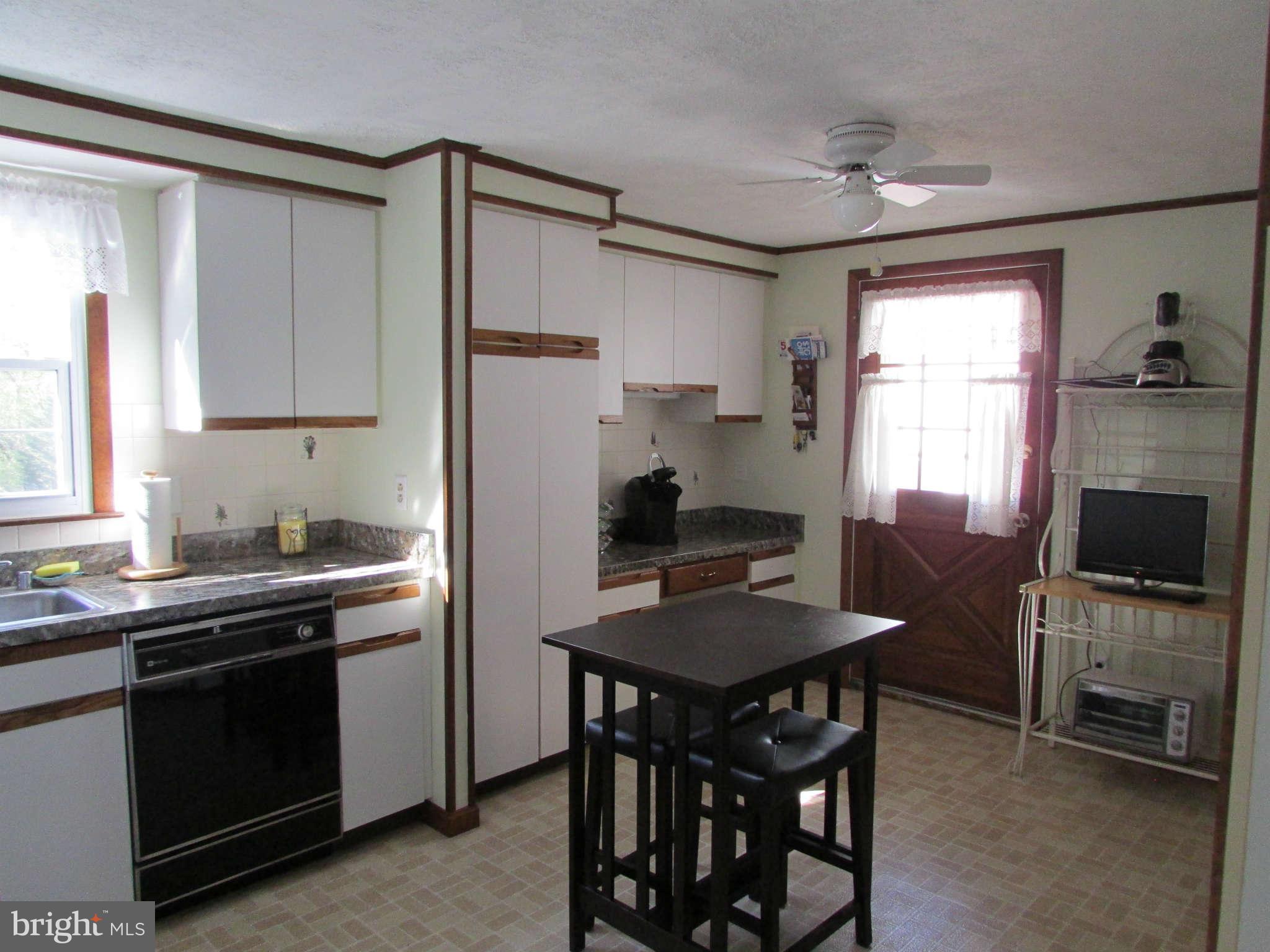 6915 Pinecrest Road Baltimore, MD 21228 - Photo 9 of 30 a kitchen with a table chairs stove and refrigerator
