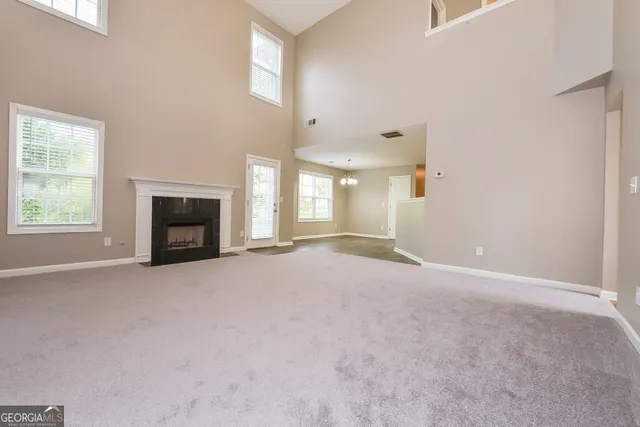 an empty room with fireplace and windows
