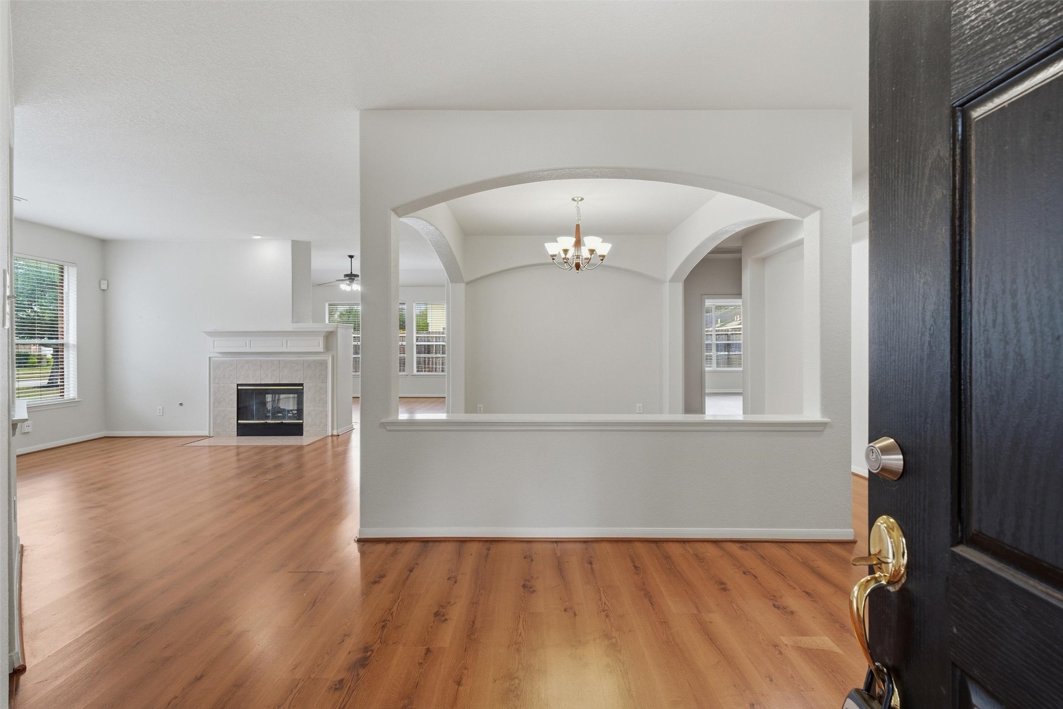 4607 Sebastopol Drive Pearland, TX 77584 - Photo 2 of 26 an empty room with wooden floor fireplace and windows
