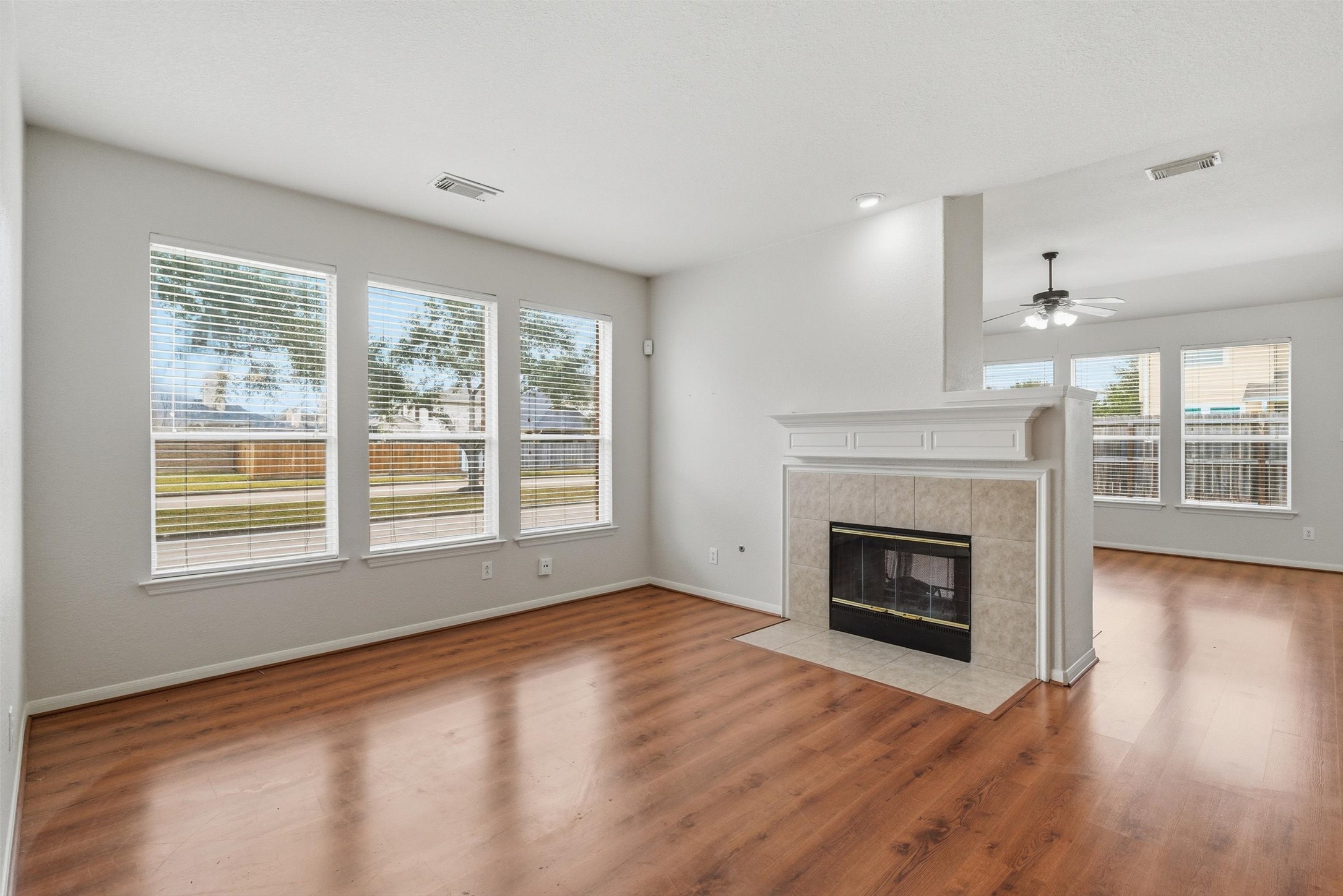 4607 Sebastopol Drive Pearland, TX 77584 - Photo 4 of 26 an empty room with wooden floor fireplace and windows