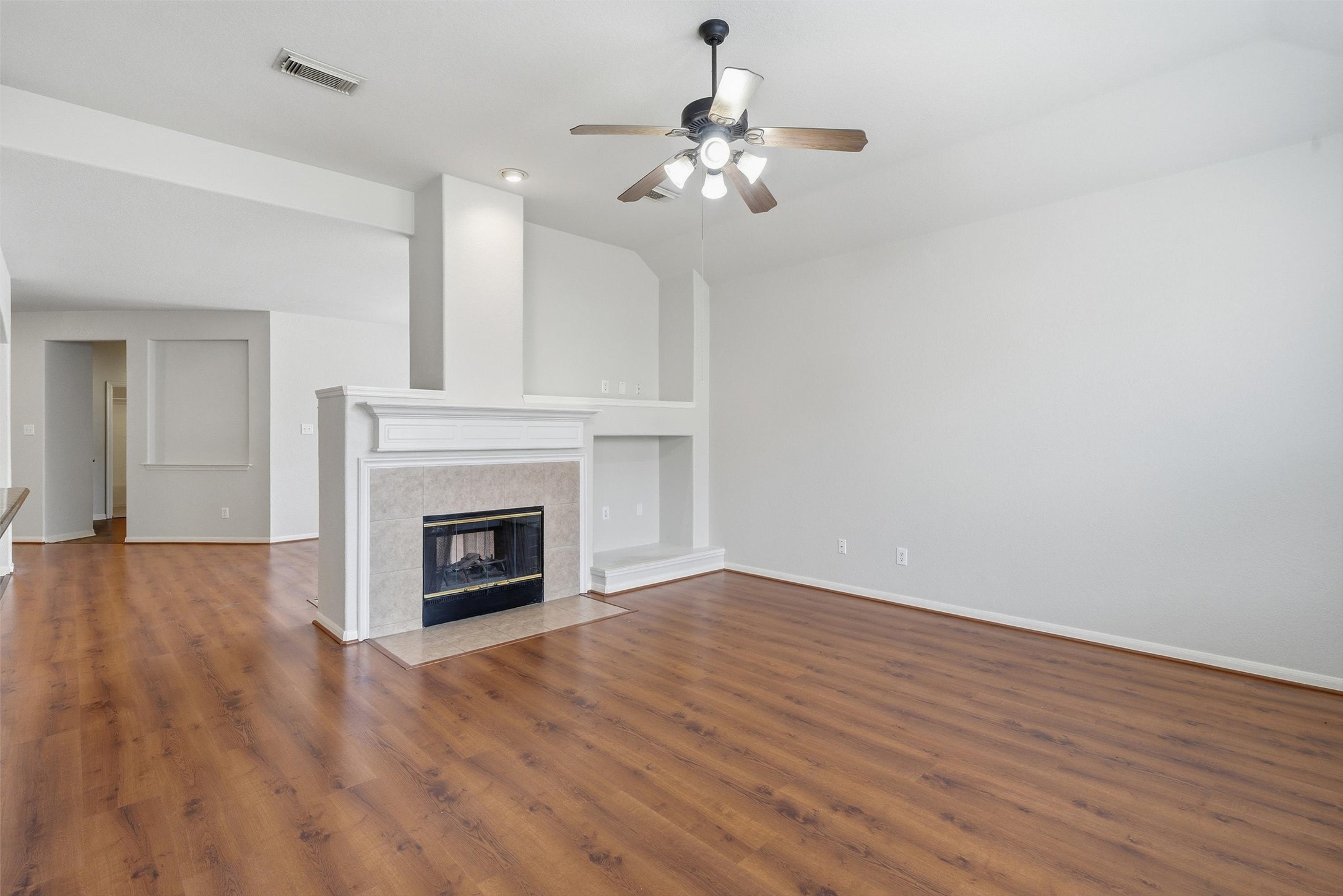 4607 Sebastopol Drive Pearland, TX 77584 - Photo 7 of 26 a view of a livingroom with a fireplace a chandelier and wooden floor