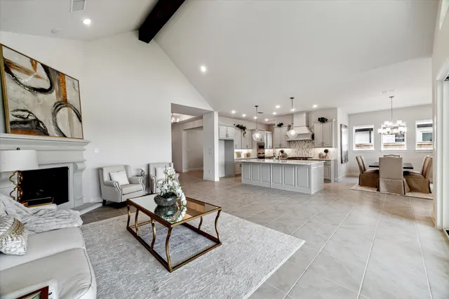 a large white kitchen with lots of counter space and stainless steel appliances