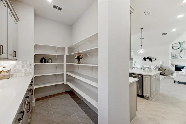 a large white kitchen with a large window and couch