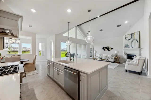 a large kitchen with kitchen island a sink a stove a center island a stove and a view of living room