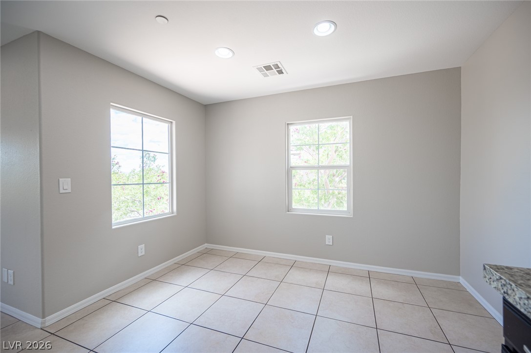 9916 Sable Point Street Las Vegas, NV 89178 - Photo 40 of 73 A well-lit room featuring ample natural light from two windows and practical tile flooring.