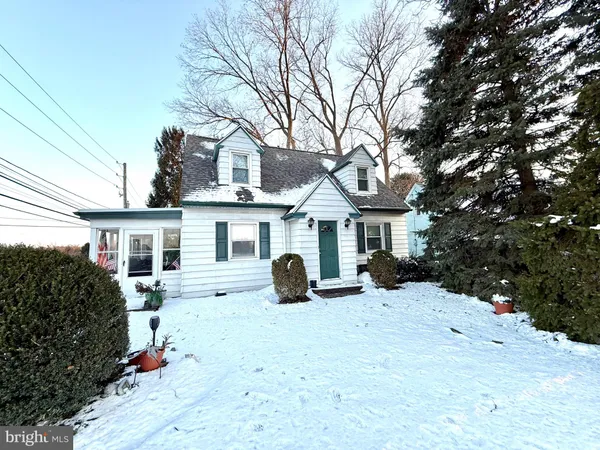 a view of a white house with a yard covered in snow