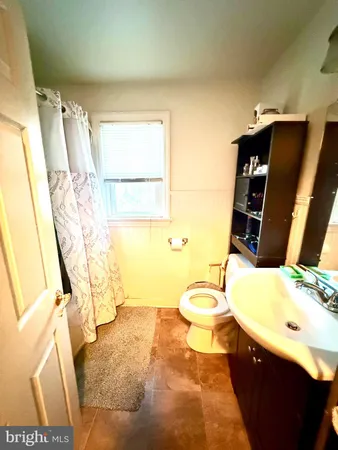 a bathroom with a sink vanity mirror and toilet
