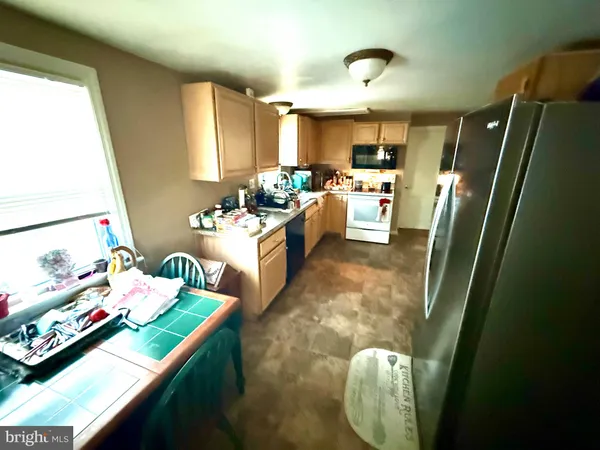 a kitchen with kitchen island stainless steel appliances a sink stove and refrigerator