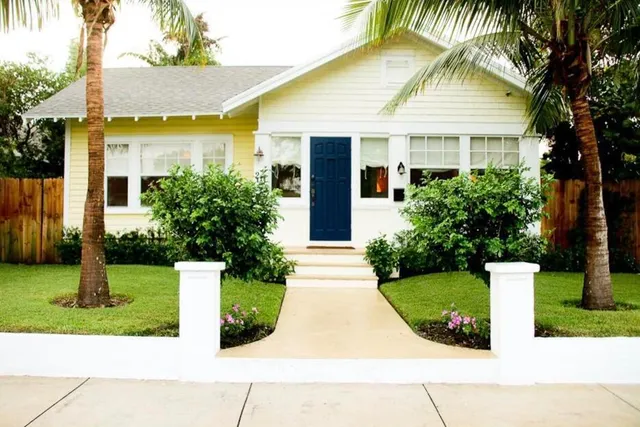 a front view of a house with a yard and trees
