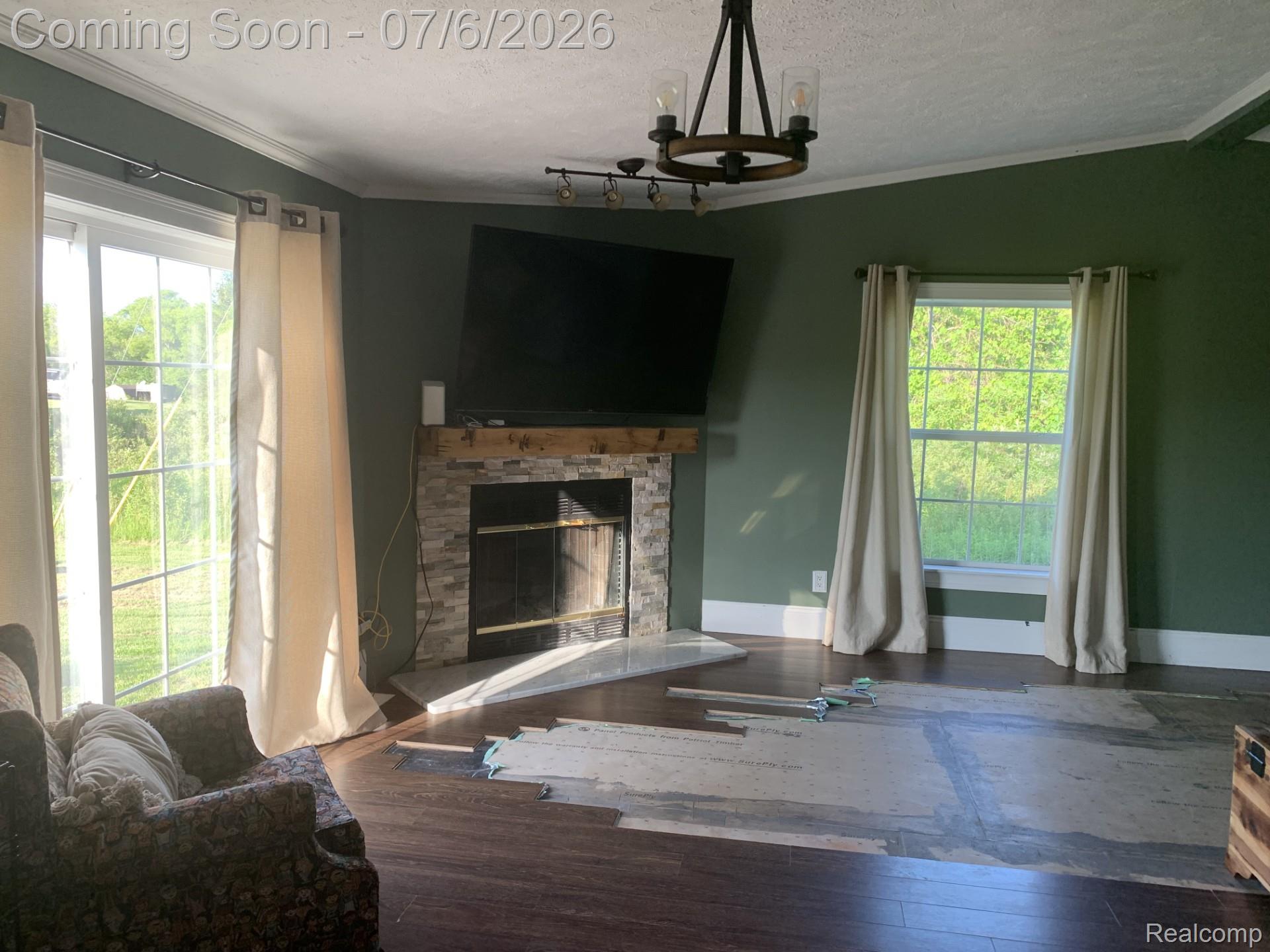 4168 Harris Road Fort Gratiot, MI 48059 - Photo 12 of 30 Living area with a stone-clad fireplace and a wood mantle