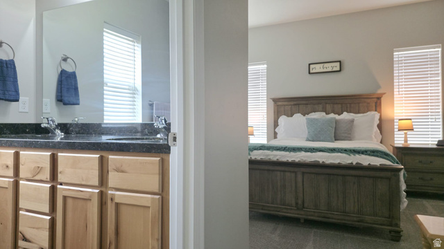 1437 925 South Vernal, UT 84078 - Photo 9 of 47 Spacious bedroom featuring light gray walls, two windows with horizontal blinds, and carpet flooring