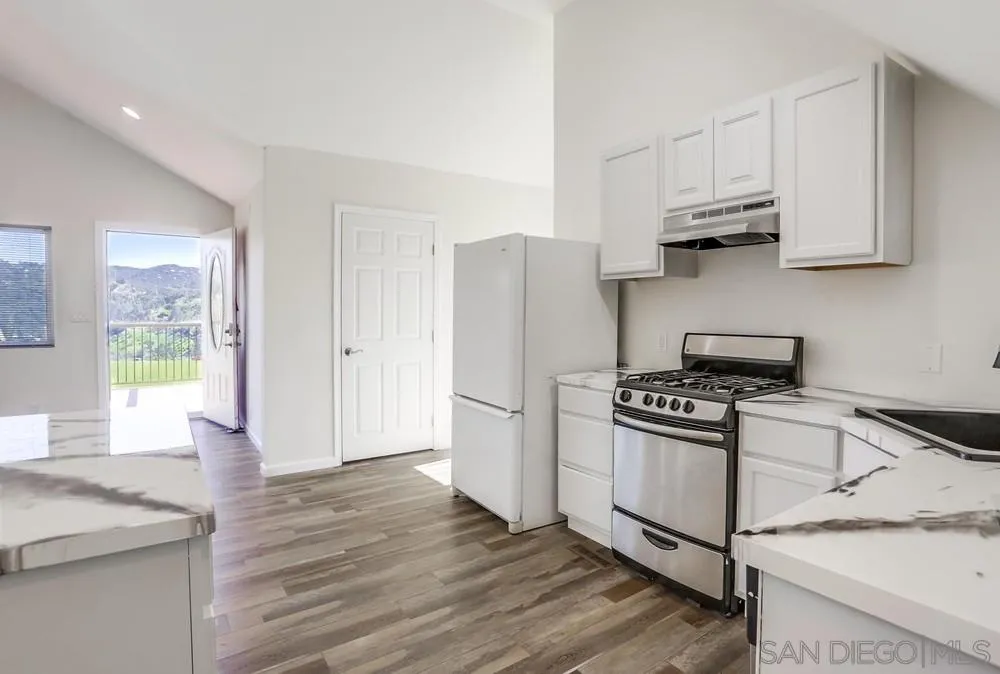 39431 American Road Fallbrook, CA 92028 - Photo 49 of 62 a kitchen with granite countertop white cabinets and white appliances