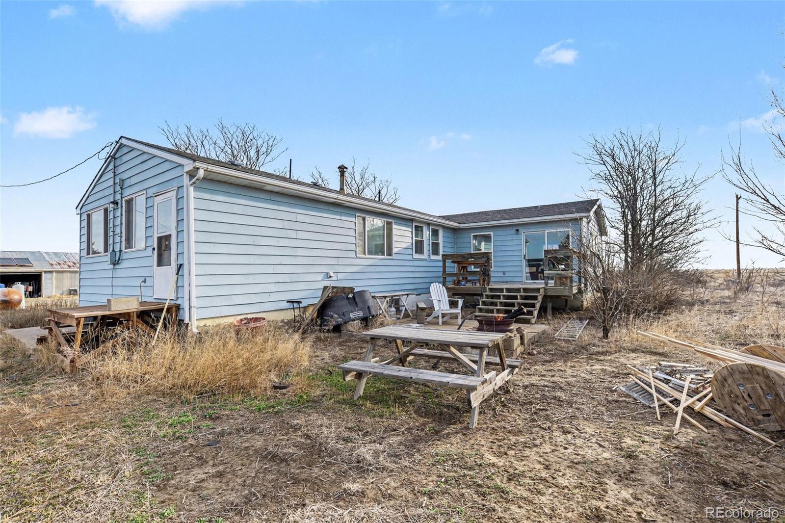 901 County Road 3 Wiggins, CO 80654 - Photo 18 of 28 a view of a house with backyard and sitting area