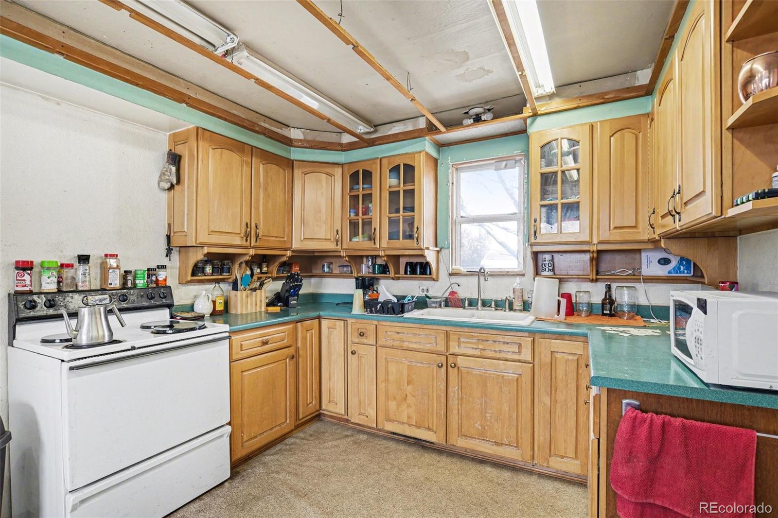 901 County Road 3 Wiggins, CO 80654 - Photo 9 of 28 a kitchen with a sink stove and cabinets