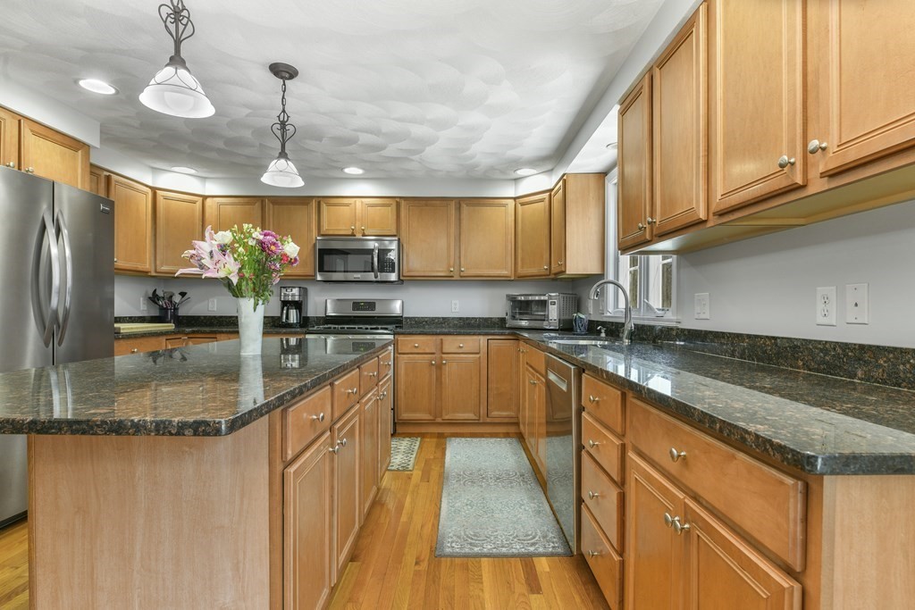 211 Pearl Street Reading, MA 01867 - Photo 11 of 34 a kitchen with stainless steel appliances granite countertop a sink a counter space cabinets and appliances