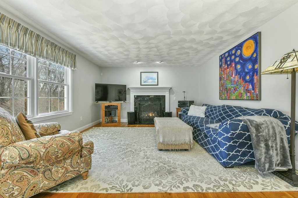 211 Pearl Street Reading, MA 01867 - Photo 15 of 34 a living room with furniture a flat screen tv and a fireplace