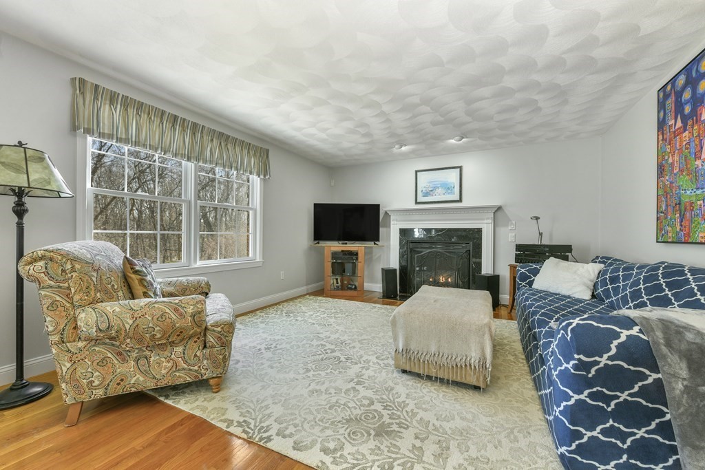 211 Pearl Street Reading, MA 01867 - Photo 16 of 34 a living room with furniture a flat screen tv and a fireplace