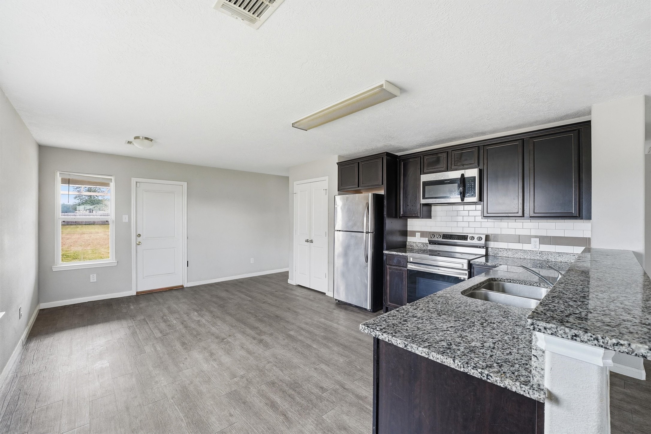 47 Road 5103 Cleveland, TX 77327 - Photo 11 of 33 a kitchen with stainless steel appliances granite countertop a sink stove and refrigerator