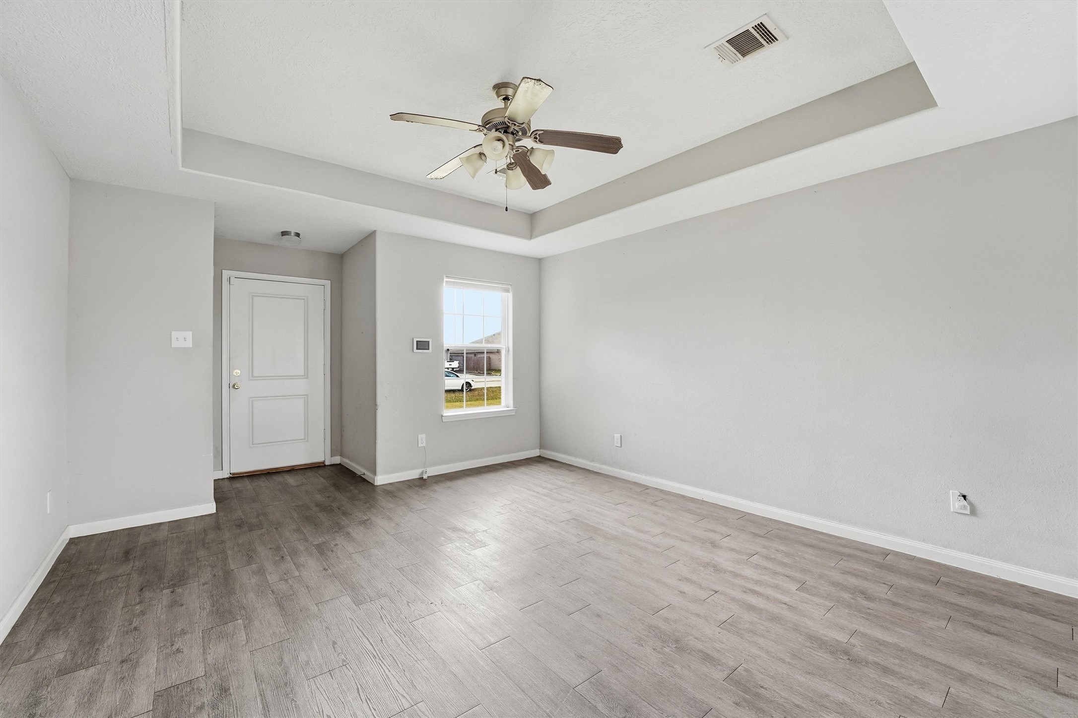47 Road 5103 Cleveland, TX 77327 - Photo 9 of 33 an empty room with wooden floor chandelier fan and windows