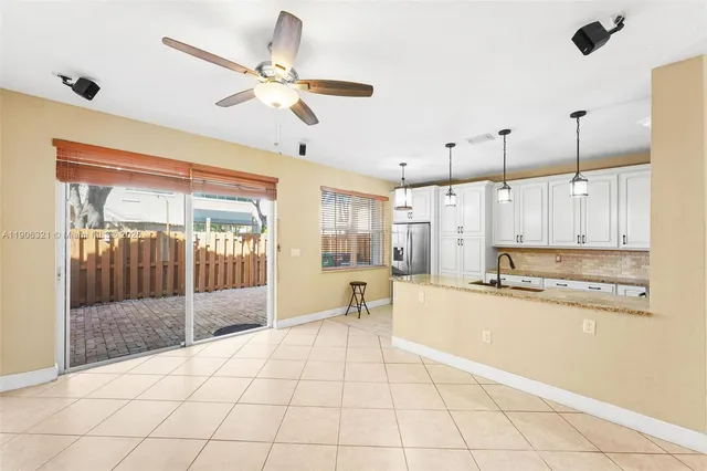 a large kitchen with stainless steel appliances kitchen island granite countertop a sink and cabinets