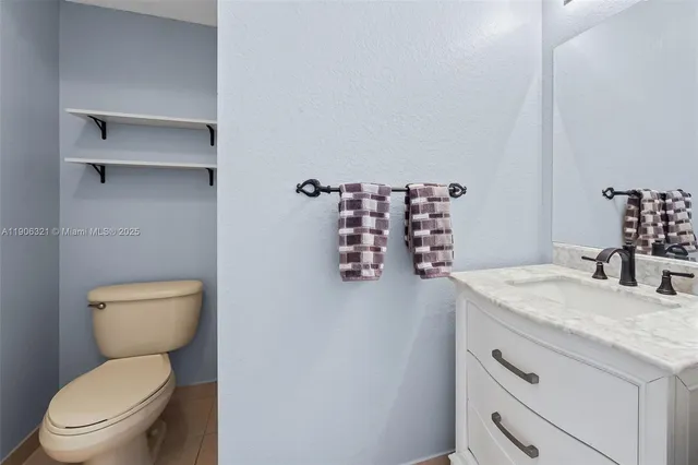 a bathroom with a granite countertop toilet sink and mirror