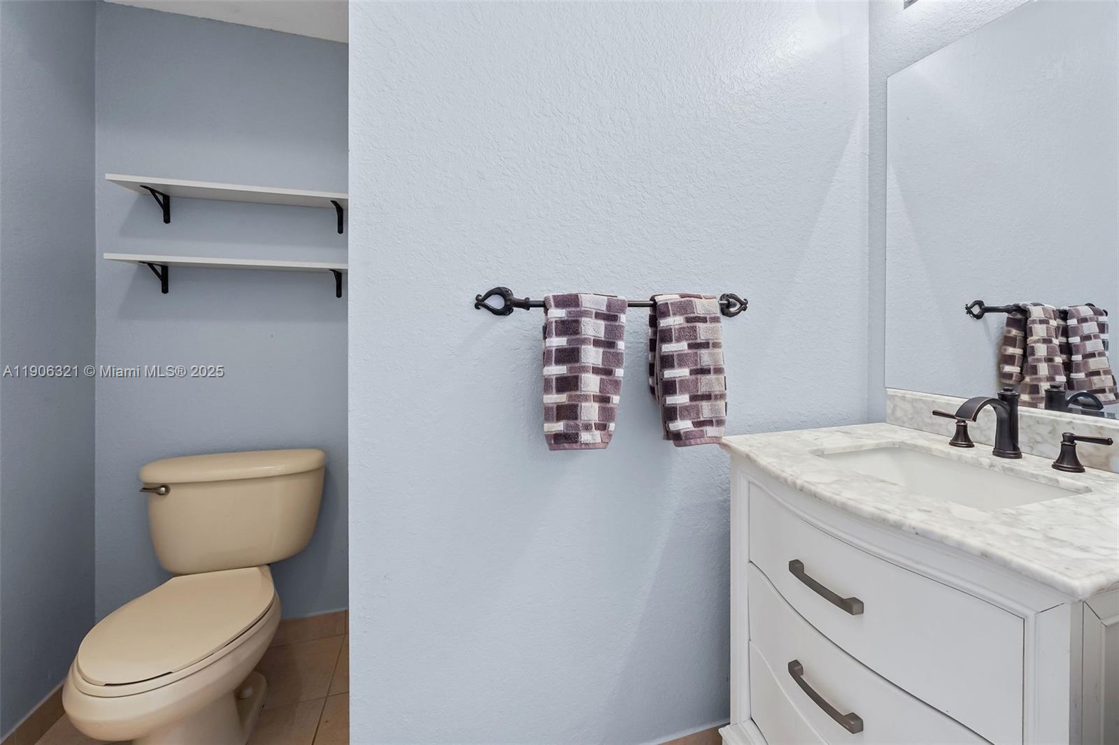 12513 Southwest 121st Way Miami, FL 33186 - Photo 14 of 37 a bathroom with a granite countertop toilet sink and mirror