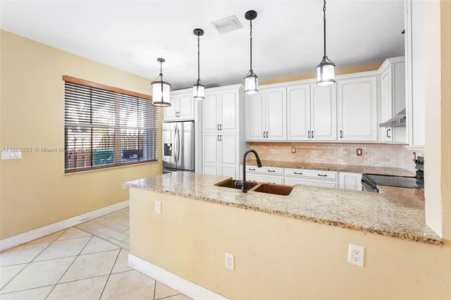 a kitchen with stainless steel appliances granite countertop a sink a microwave and a granite counter tops