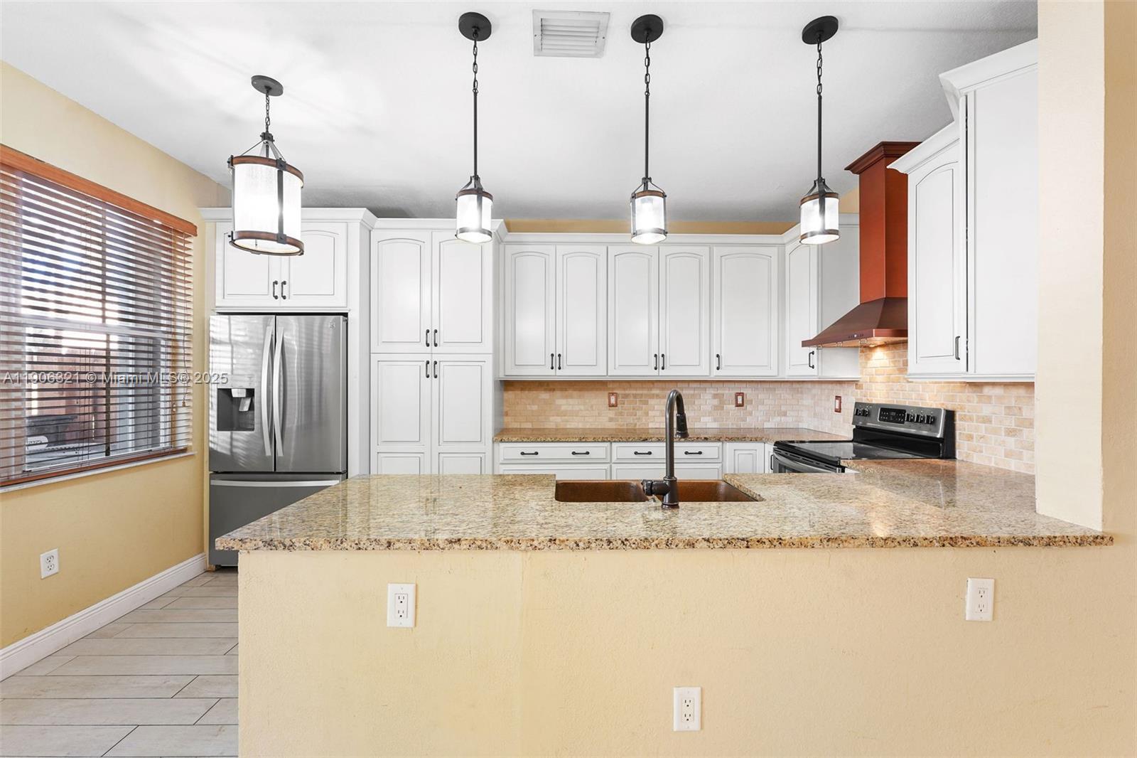 12513 Southwest 121st Way Miami, FL 33186 - Photo 16 of 37 a kitchen with stainless steel appliances granite countertop a sink a stove and a refrigerator