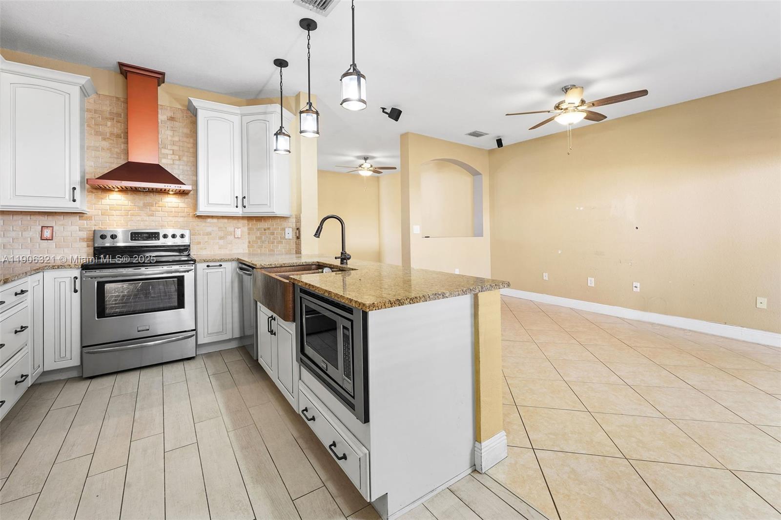 12513 Southwest 121st Way Miami, FL 33186 - Photo 17 of 37 a kitchen with stainless steel appliances granite countertop a sink a stove and a refrigerator